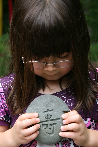 photograph of Dova holding a stone with the Chinese symbol of longevity