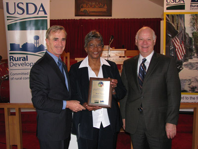 Mable Friend, is presented a plaque in recognition for her dedication and outstanding commitment to the residents of Jonestown by Sen. Ben Cardin and USDA's Jack Tarburton