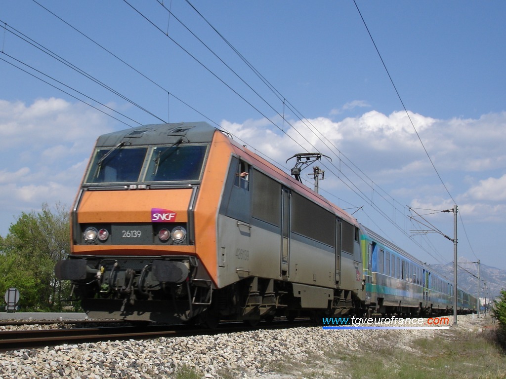 Une locomotive bi-tension BB26000 avec le nouveau logo SNCF se dirige vers la gare de La Penne-sur-Huveaune le 25 avril 2006.