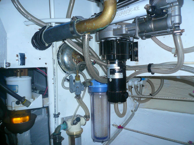 Looking under the galley sink at the fuel filter access and Katadyn Powersurvivor Watermaker system (including the coarse strainer I added before the primary filter)