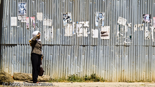 An Ethiopian woman awaits public transportation by the side of the road in Addis Ababa..