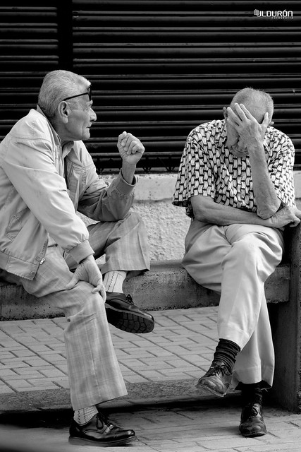 Adultos mayores (ancianos) platicando en una banca