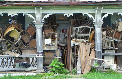 Front porch of a house piled full of junk