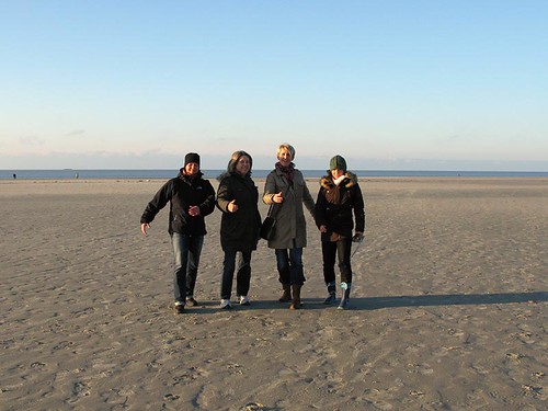 four ladies walking on the beach