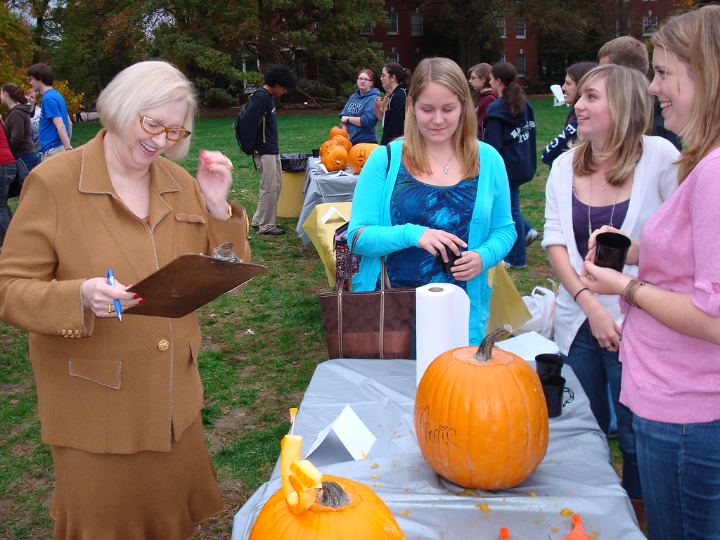 President Judy Hample judges this years crop of pumpkins while students look on.