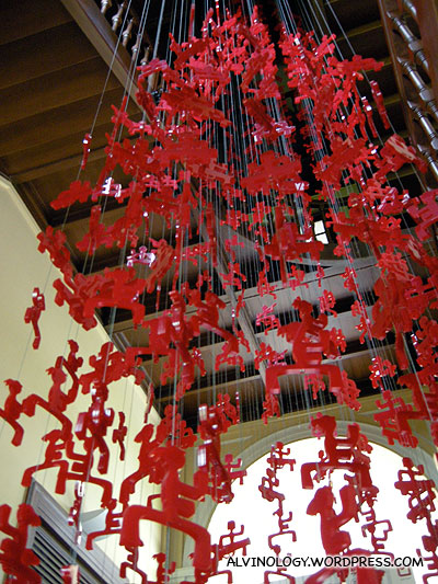 Plastic red figurines hanging from the ceiling - the figurines represent various galleries in the museums