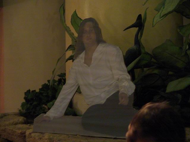 Life size cardboard cutout of man sitting in semi-reclined position.