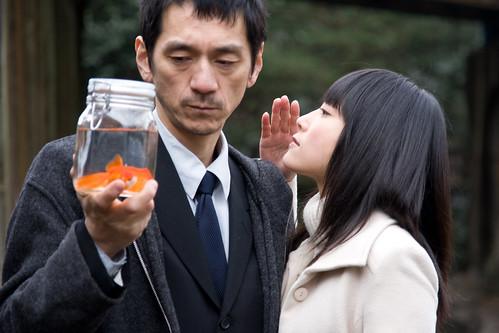 The woman (Rukino Fujisaki) whispers something to the man (Takao Kawaguchi)