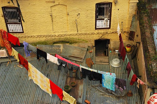 Rooftop laundry, clothes hanging, entrance, barred windows, aluminum floor, monks clothes, bucket, planters, Bodha, Kathmandu, Nepal by Wonderlane