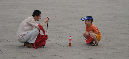 Father and son with flag, camera, and empty drink bottle, Tian'anmen Square