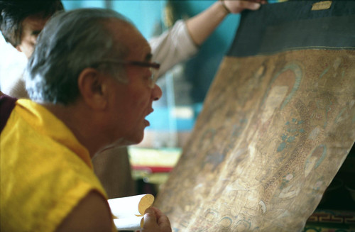 His Holiness Dagchen Sakya Rinpoche examining a very old Thangka (Sakya Pandita?) at the Tibetan Works and Archives Library in Dharamsala, India 1993 by Wonderlane