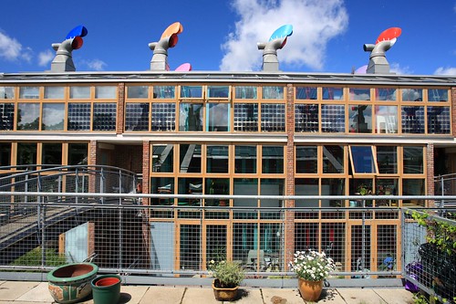BedZED社區的建築識別元素：三層樓高的南向溫室、整合式太陽能光電板、彩色風杓。