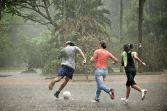 Teenagers playing soccer in the rain