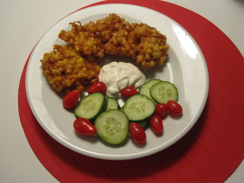 Corn fritters with cucumber slices, tomatoes and sour cream at home