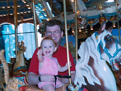 Speck on a carousel horse, waving at Papou