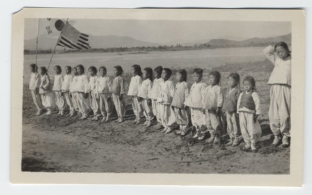 [Line of children (orphans?) with American and Korean flags]