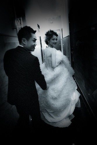 新郎牽著新娘的裙襬要進房換下一套禮服，新娘開心地回頭想要留下一張照片。