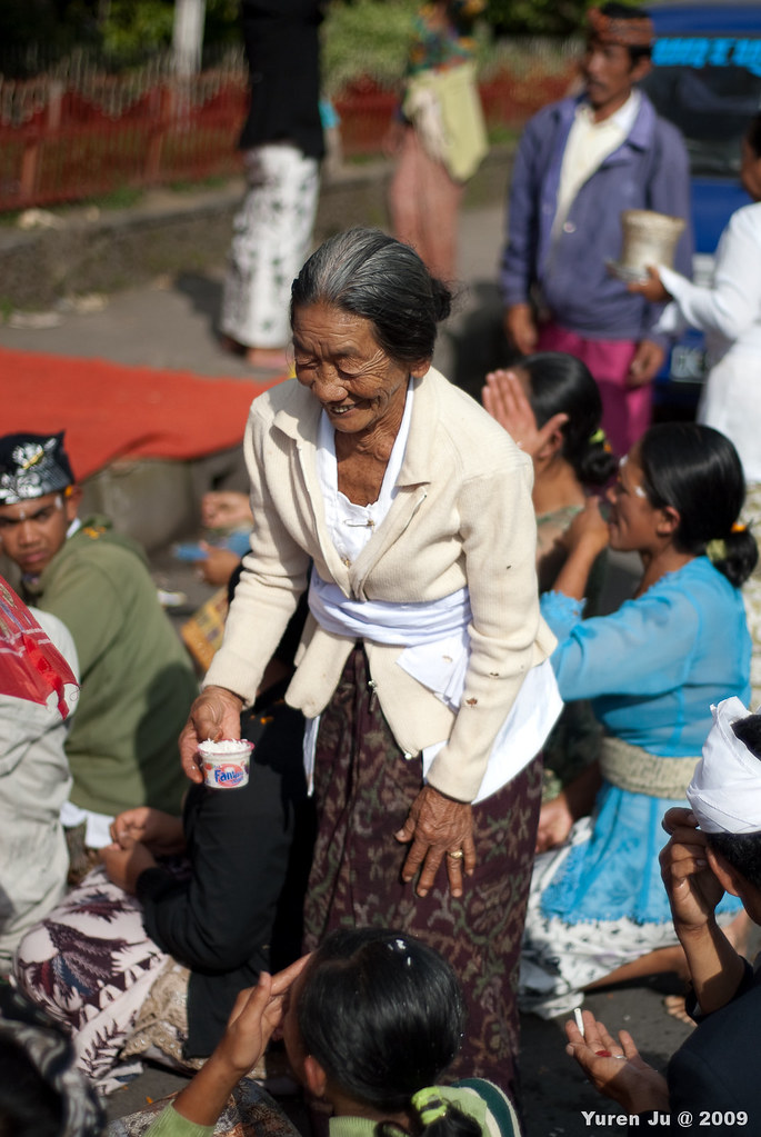這位婆婆正在幫拜拜的人群頭上黏米