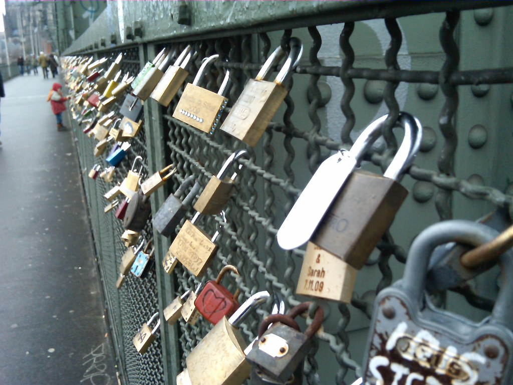 Many locks decorate the fence along the bridge footpath.