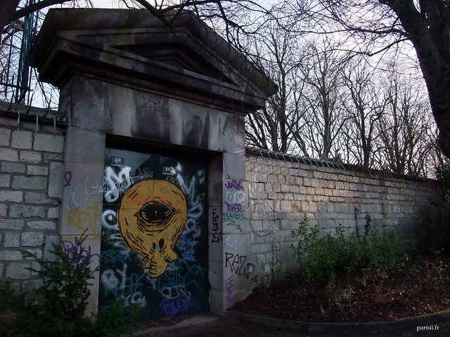 Une porte d'entrée du Père Lachaise, soigneusement décorée d'un graffiti