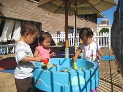 Aki playing in the sand table with new friends