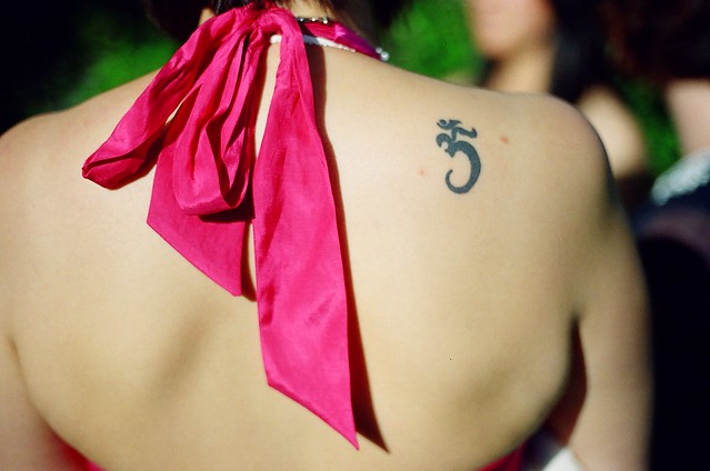 I think that the tattoo is a representation of the Universal mantra - AUM or 