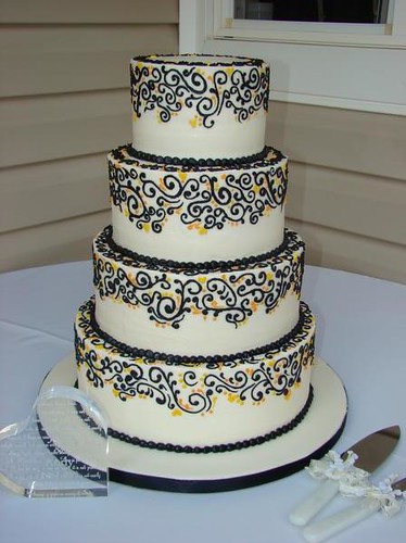 4 tier ivory buttercream wedding cake with black srcolls and yellow and 