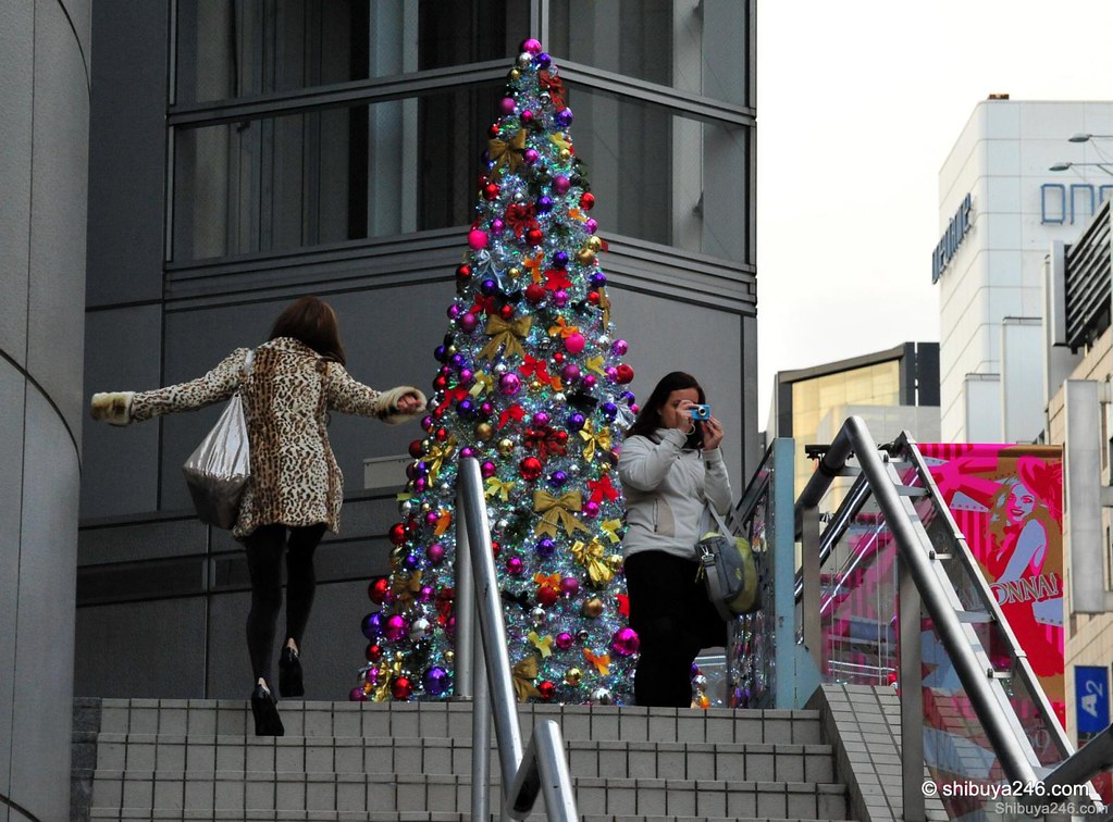 Great colors for a xmas tree here at the top of the stairs for 109 store. The girl on the left seems pleased to see the tree as well.