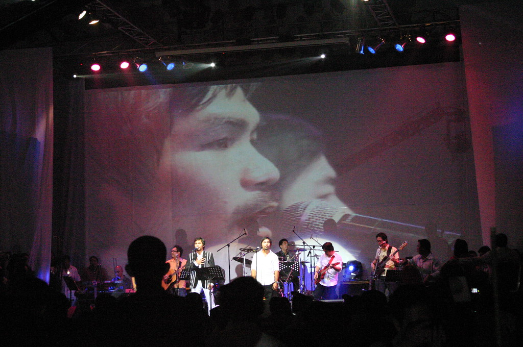 "A GIANT SCREEN SHOWS THE LIVE FOOTAGE OF MANNY PACQUIAO AND COMPOSER LITO CAMO PERFORMING ON STAGE.  BOTH SANG ABOUT 15-20 SONGS."