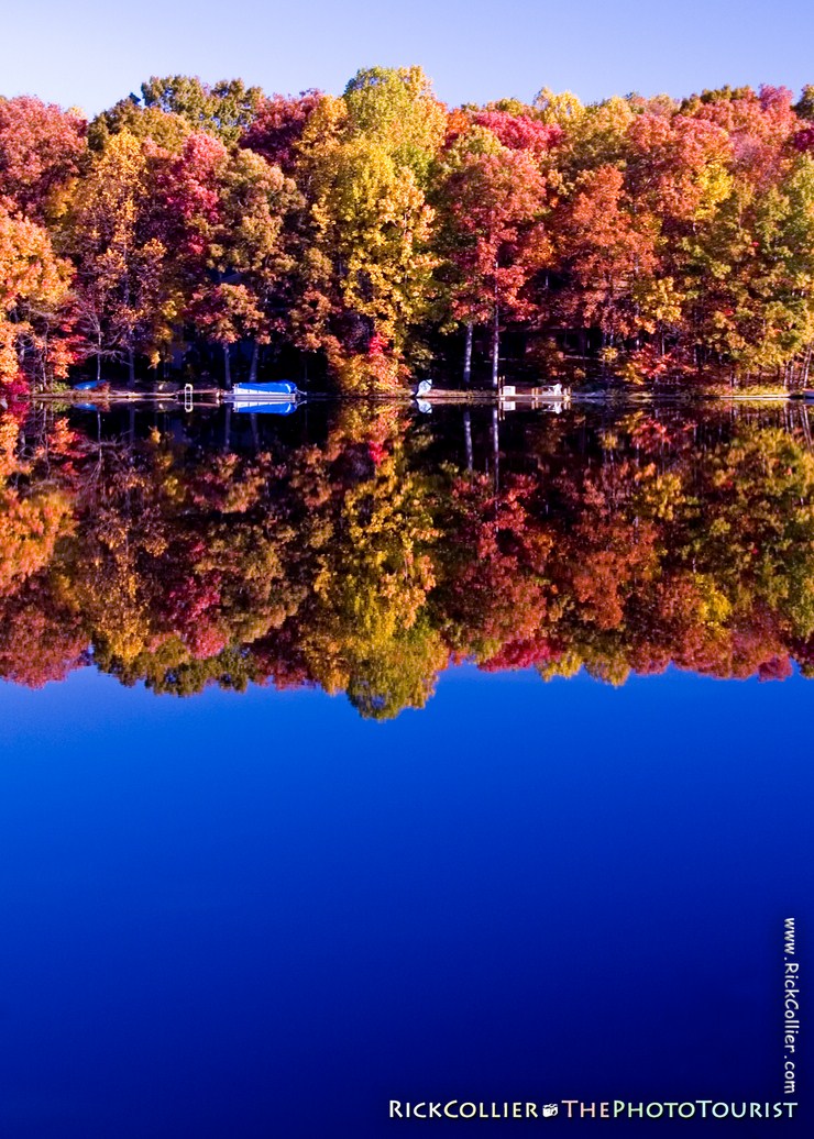Boats are put away for the season, parked under the brightly colored foliage of fall, at Lake Thoreau in Reston, Virginia, USA.