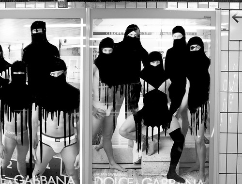 A Dolce & Gabbana ad featuring young men in underwear has been hit by Princess Hijab. Their upper-bodies have been spray-painted with black hijabs and headscarfs. The paint drips down their exposed lower-bodies.