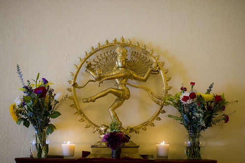 Golden Statue surrounded by flowers and lit candles