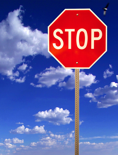 Stop sign on blue cloudy sky by emagine6.