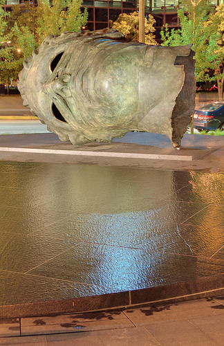 Bronze sculpture, "Eros Bendato" (Eros Bound) by Igor Mitoraj, with scrim fountain in foreground, at the Citygarden, in Saint Louis, Missouri, USA - view at night