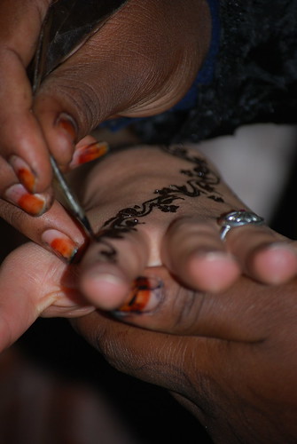 Woman drawing a henna tattoo on Isabelles hand