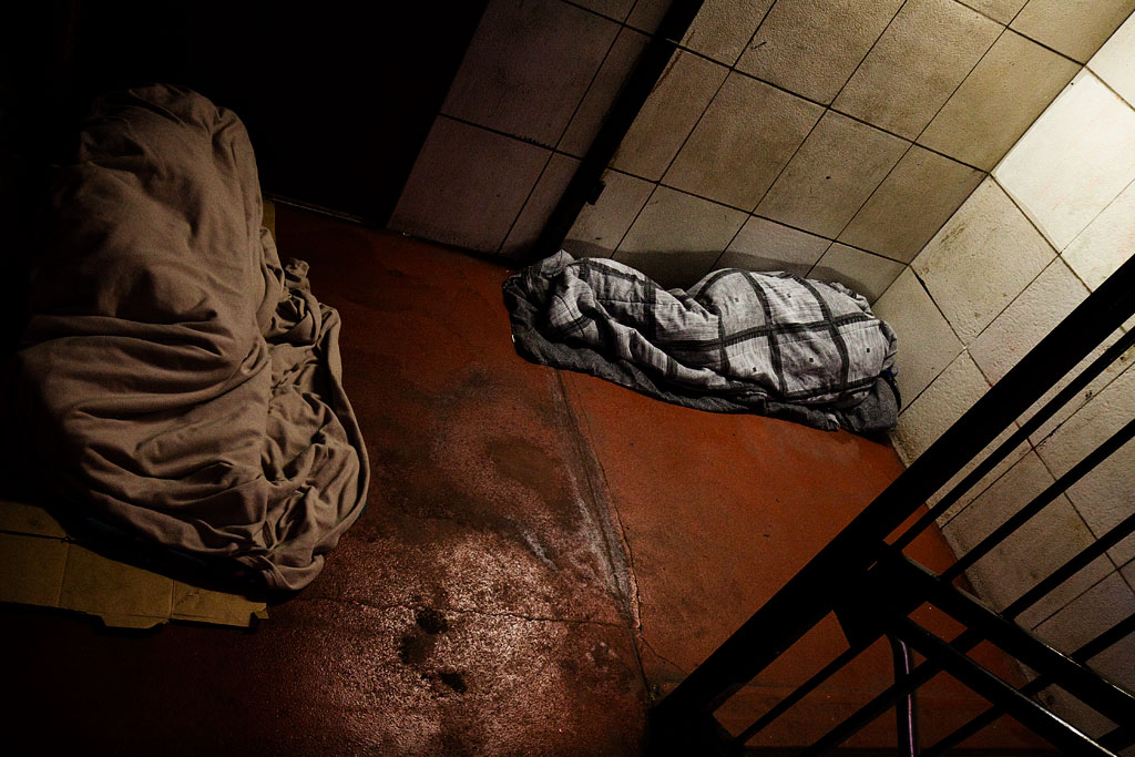 Two-sleeping-figures-in-subway-entrance--Center-City