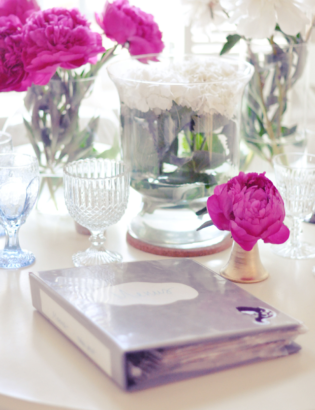 take  out menus  in a binder + pink peonies and crystal on kitchen table