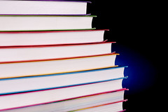 Stack of colorful books with blue light behind them