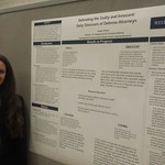 A student posing with her research poster
