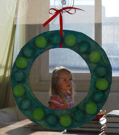 ping pong ball holiday wreath hanging from a window 