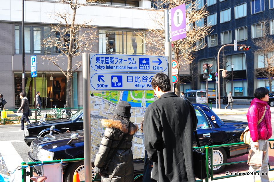 Some people looking for directions outside Yurakucho Station. You can see the big green area on the map here is part of the gardens and start of the Emperor's Palace grounds.