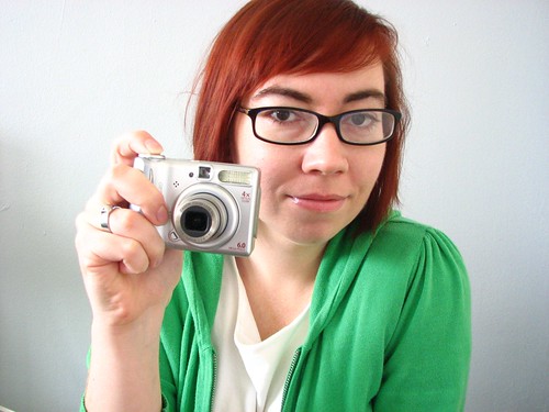 Cute fun quirky self portrait of redhead with glasses and camera