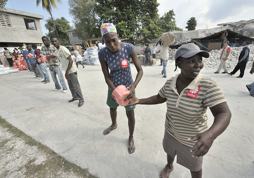 HAITI/QUAKE by Jesuits In The U.S.. Earthquake survivors in the quake-ravaged Haitian city of Leogane unload emergency supplies provided.
