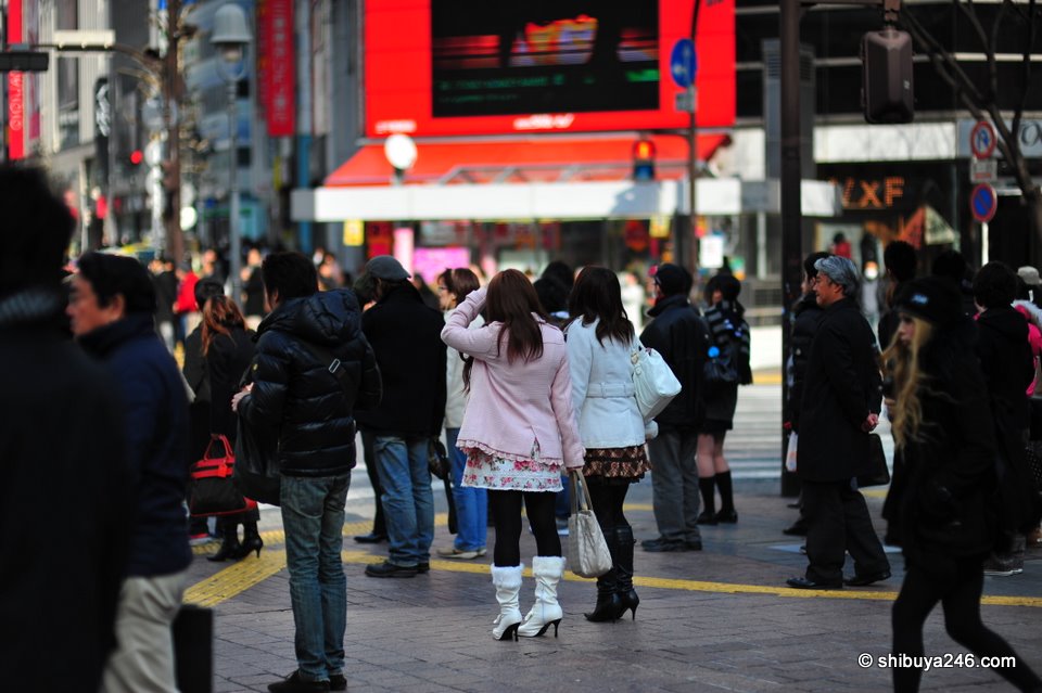 People starting to gather waiting to cross. Shibuya fashion can be bags, clothes or even just face masks.
