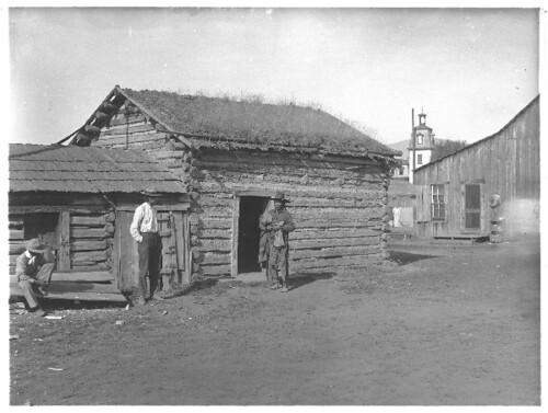 Three Indian Men in Front of a Cabin