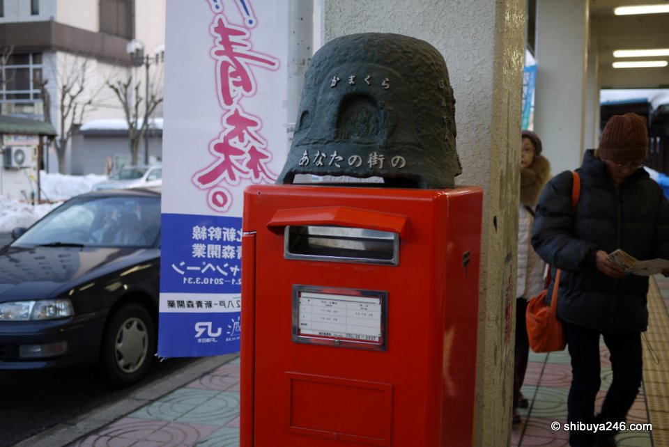 A kamakura decoration on top of the post box outside the station.