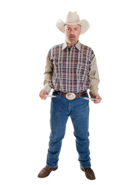 Isolated full length stock photo of a broke cowboy looking at the camera with a stunned expression and his pockets turned out.