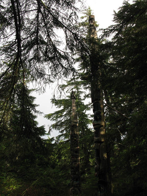 a peek at totems of Kasaan Totem Park through trees, Kasaan, Alaska