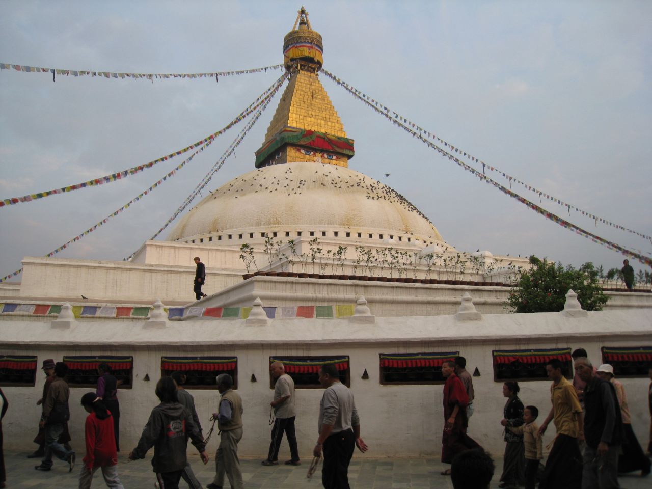 Tibetans walk clockwise around the stupa at sunset (note the malas they hold in their hands)