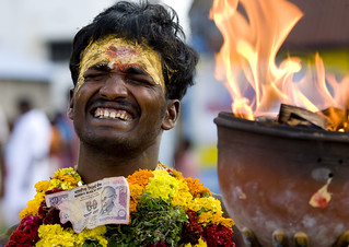 Suffering Man With Traditional Painting On His Forehead Holding A Jar On Fire During A Fire Walking Ritual, Madurai, South India